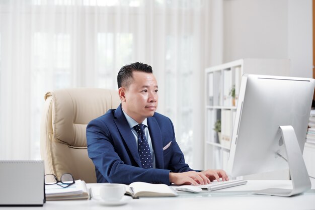 Juristischer Mitarbeiter, der in seinem Büro im Internet surft