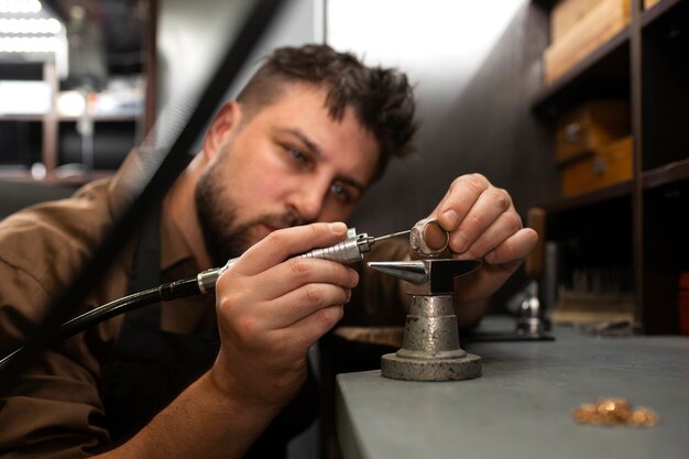 Juwelier mit mittlerer Aufnahme, der Schmuck herstellt