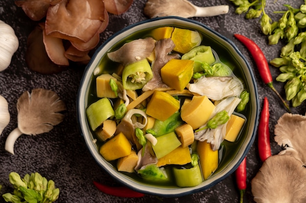 Kaeng Liang in einer Schüssel mit Gewürzen auf einem schwarzen Zementboden.