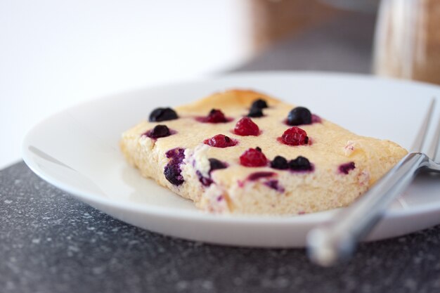 Käse-Auflauf mit Waldbeeren in einer weißen Platte