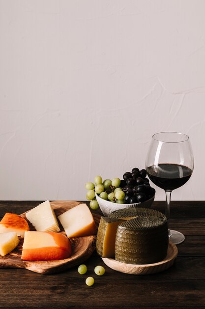Käse und Trauben in der Nähe von Wein