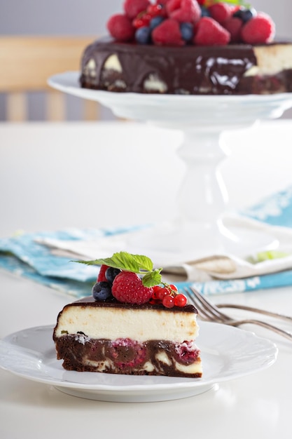 Käsekuchen mit Beeren auf einer Brownie-Schicht