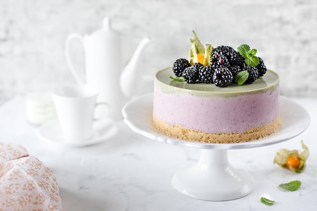 Käsekuchen mit Beeren und Spinat ohne Backen auf weißem Hintergrund