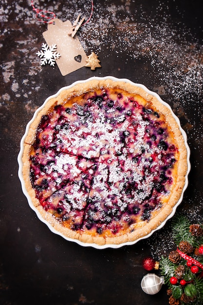 Käsekuchen mit Himbeeren auf einem dunklen Holztisch