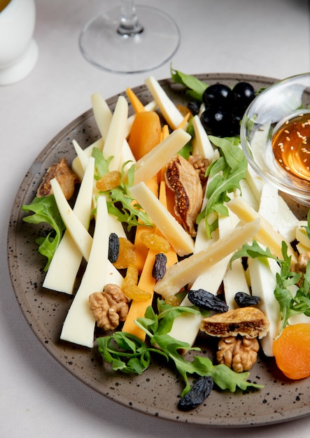 Käseplatte mit Nüssen Rosinen Rucola und Oliven