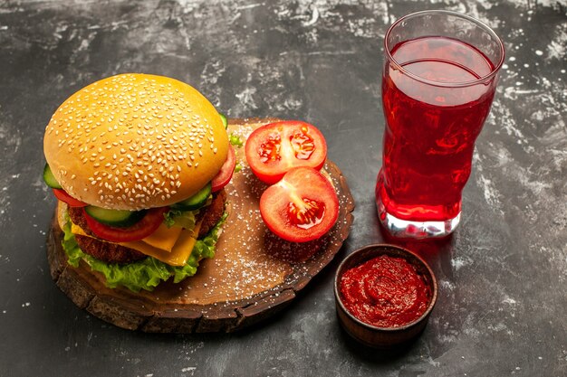 Käsiger Fleischburger der Vorderansicht mit Saft auf dunklem Oberflächen-Sandwich-Fast-Food-Brötchen