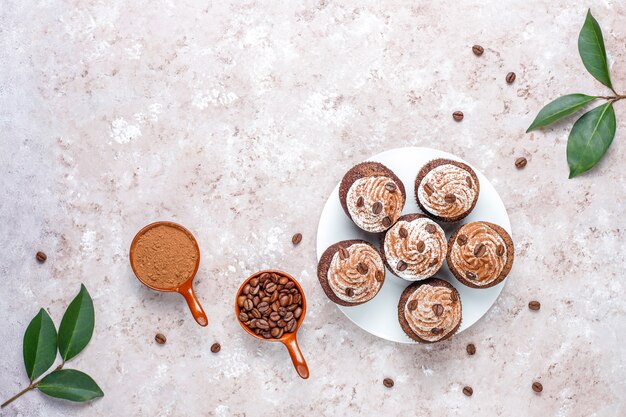 Kaffee Cupcakes mit Schlagsahne und Kaffeebohnen dekoriert.
