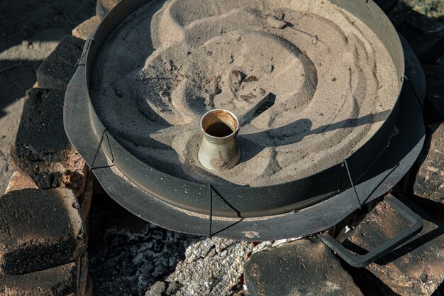 Kaffee in einem Türken auf dem Sand, der türkischen Kaffee macht.