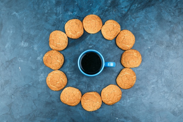 Kaffee in einer tasse mit keksen auf einem dunkelblauen hintergrund