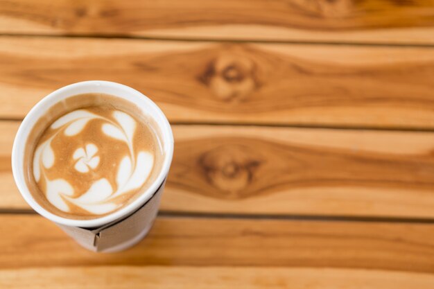 Kaffee mit Herz-Muster auf Holzuntergrund