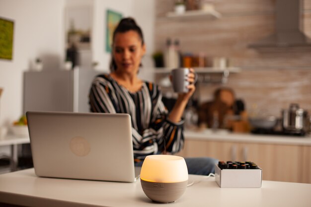 Kaffee trinken und mit Aromatherapie mit ätherischen Ölen aus dem Diffusor arbeiten