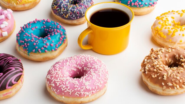 Kaffee, umgeben von süßen Donuts