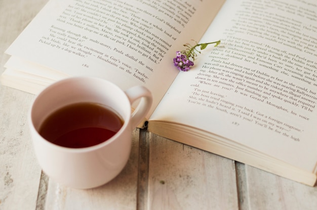 Kaffee und offenes Buch mit Blumen im Inneren