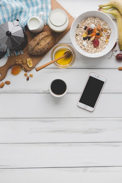 Kaffee und smartphone nahe frühstückslebensmittel