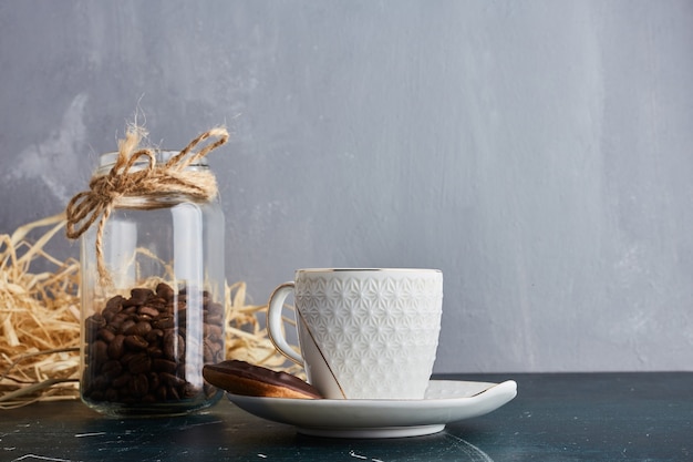 Kaffeebohnen in einer Holzschale in einem Glas.