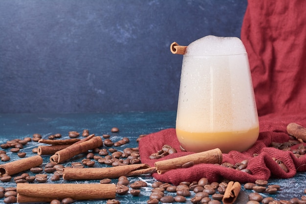 Kostenloses Foto kaffeebohnen mit einer tasse getränk auf blau.