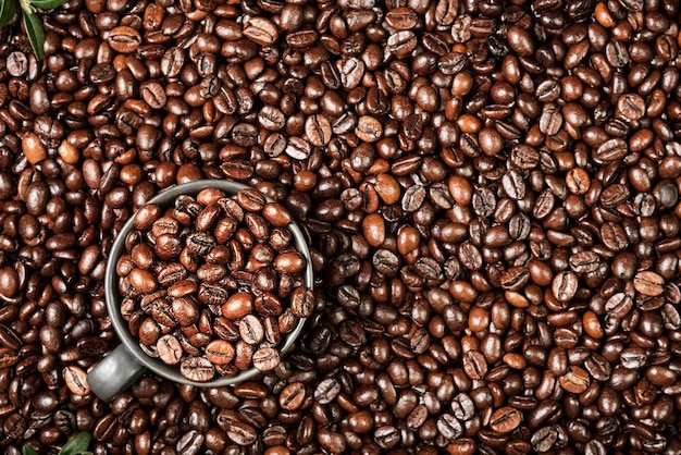 Kaffeehintergrund mit platz für text, layout von kaffeebohnen auf dem tisch und schwarze tasse für espressokaffee, kaffeewerbeidee