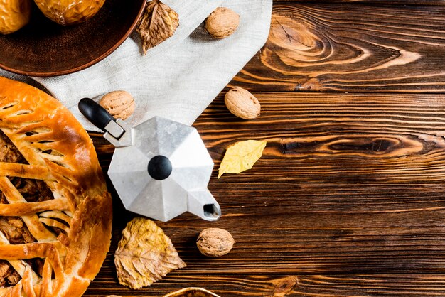 Kaffeekanne in der Nähe von Blättern und Snacks