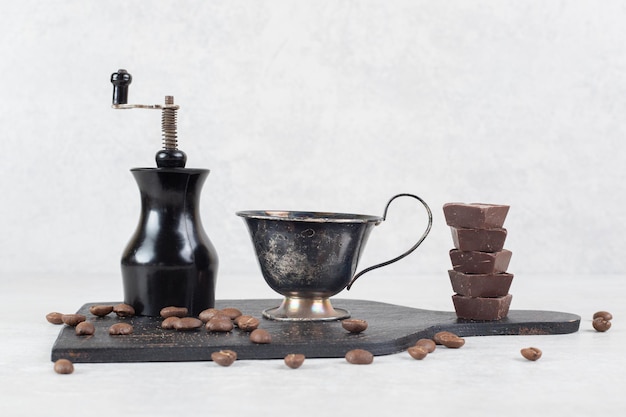 Kaffeemaschine, Kaffee und Bohnen auf dunklem Brett mahlen