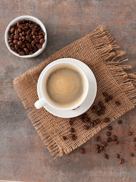 Kaffeetasse auf Sackleinen und Kaffeebohnen