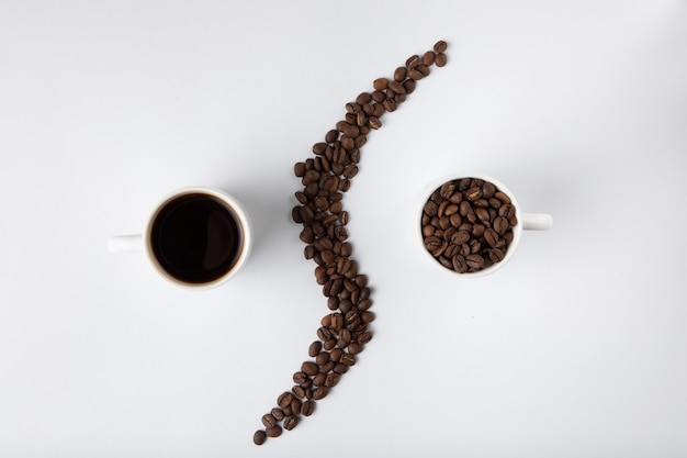Kaffeetasse mit Kaffeebohnen lokalisiert auf Weiß