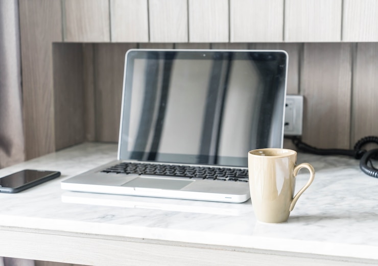Kostenlose Foto kaffeetasse mit laptop und schöne luxus tischdekoration im wohnzimmer interieur für hintergrund