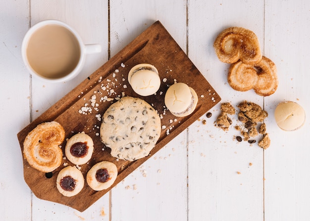 Kostenloses Foto kaffeetasse mit plätzchen auf hölzernem brett