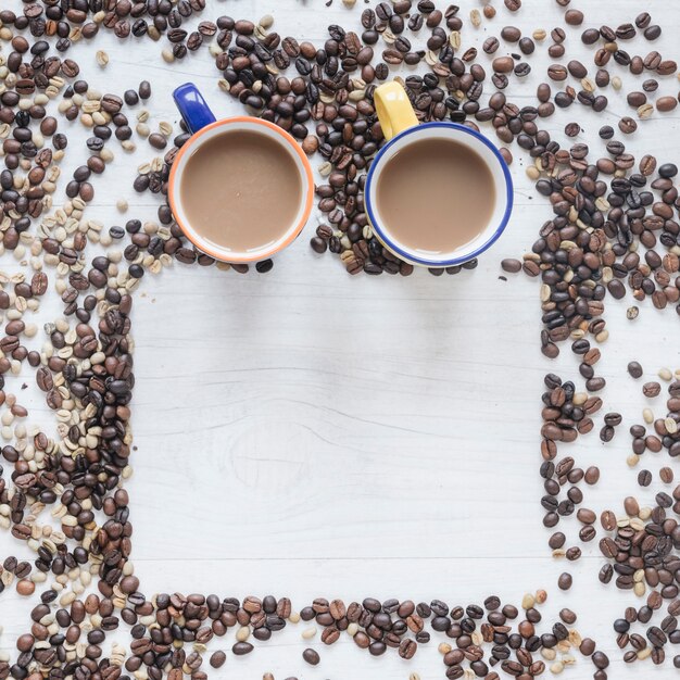 Kaffeetasse mit rohen und Röstkaffeebohnen auf hölzernem Hintergrund