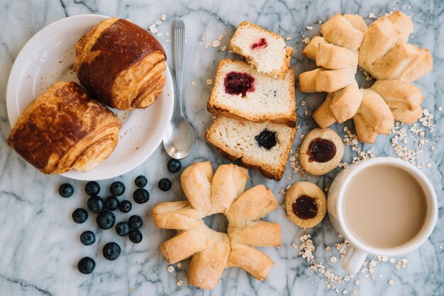 Kaffeetasse mit unterschiedlicher Bäckerei auf Marmortabelle