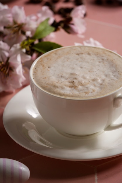 Kaffeetasse und Blumen des hohen Winkels