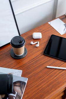 Kaffeetasse und ein digitales tablet auf einem holzschreibtisch