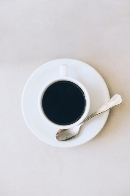 Kaffeetasse und Untertasse mit Löffel auf weißem Hintergrund