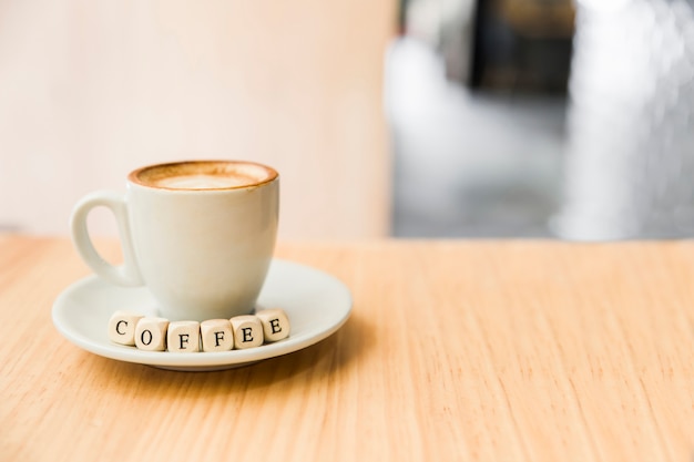 Kaffeewürfel mit Tasse Kaffee auf hölzernem Schreibtisch