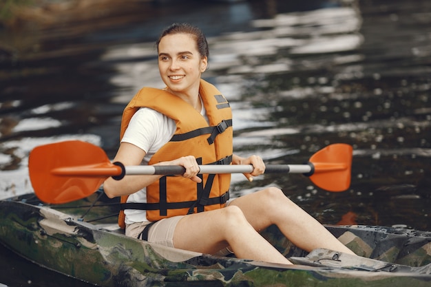 Kajak fahren. Eine Frau im Kajak. Mädchen, das im Wasser paddelt.