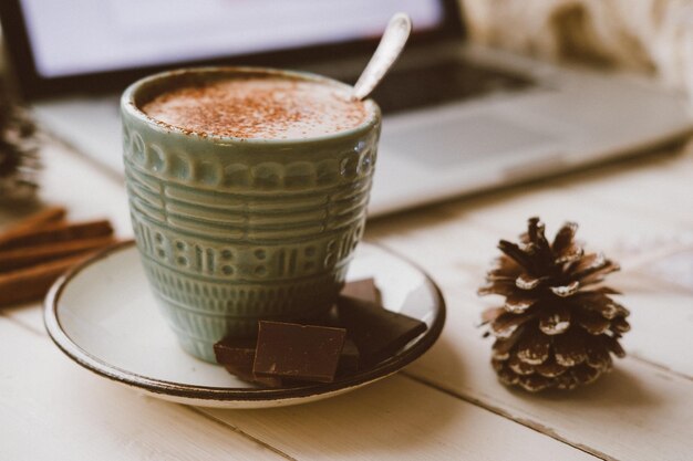 Kakao mit Laptop Gemütliches Winterhaus mit warmem Hintergrund