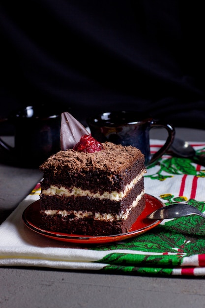 Kakaokuchen mit weißer Sahne, garniert mit geriebener Schokolade und Himbeere