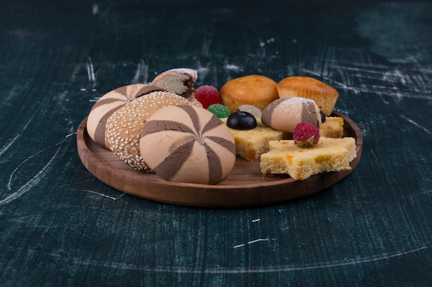 Kakaoplätzchen und Brötchen mit Beeren auf einer Holzplatte