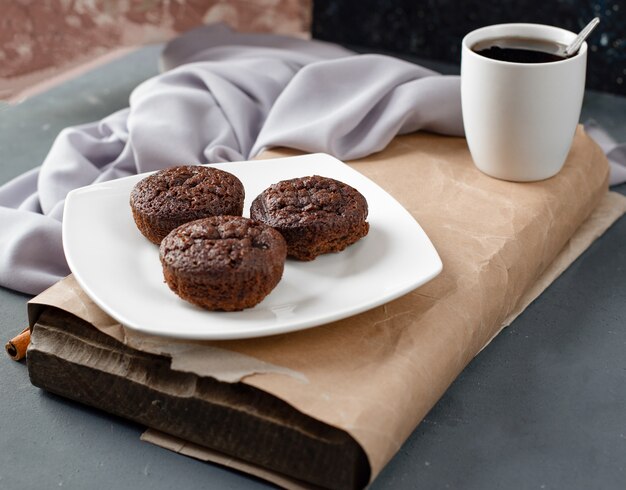 Kakaoschokoladenkuchen in einer weißen Platte mit einer Tasse Tee