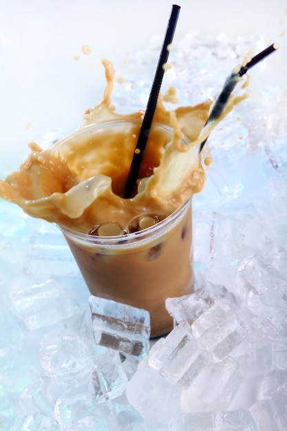 Kaltes kaffeegetränk mit eis und spritzern