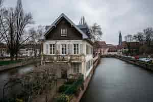 Kostenloses Foto kanal umgeben von gebäuden und grün unter einem bewölkten himmel in straßburg in frankreich