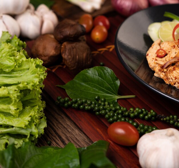 Kantonesischer Salat, frische Pfeffersamen, Knoblauch, Tomaten, Shiitake-Pilze und rote Zwiebeln auf Holzbrettern