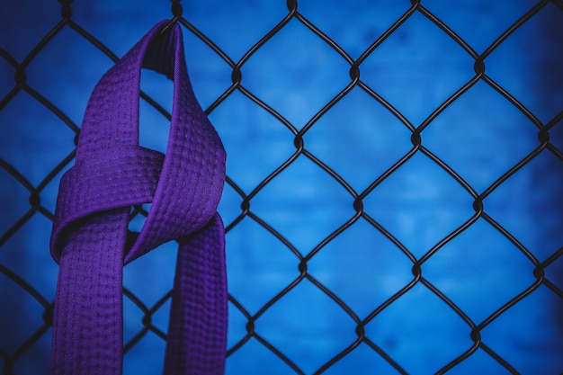 Kostenloses Foto karate lila gürtel hängt am drahtgitterzaun