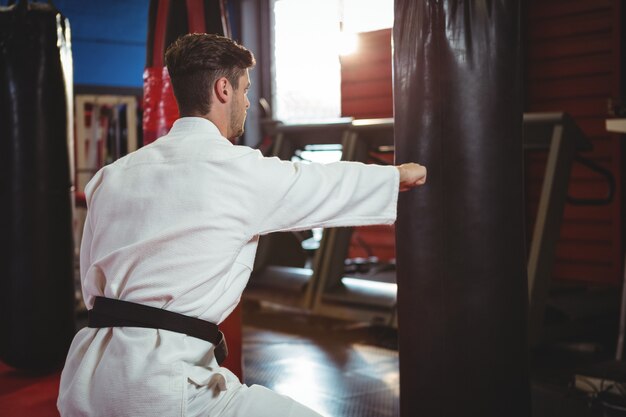 Karate-Spieler, der einen Boxsack schlägt