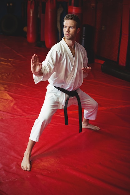 Kostenloses Foto karate-spieler, der karate-haltung ausführt
