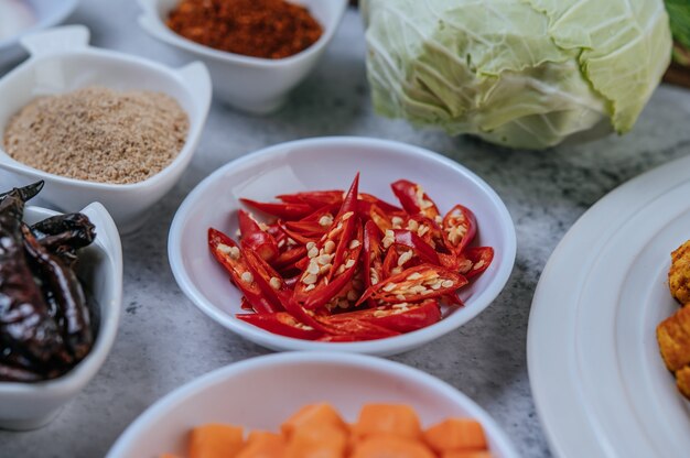 Karottenwürfel, getrocknete Chilis, gerösteter Reis, Chili und Kohl werden auf einen Zementboden gelegt