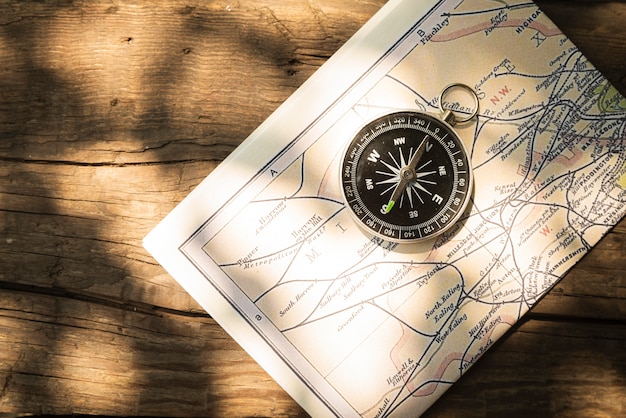 Kostenloses Foto karte und kompass mit hölzernem hintergrund