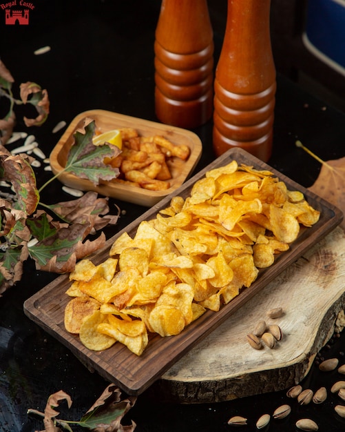 Kostenloses Foto kartoffelchips und gewürzmühlen auf dem tisch