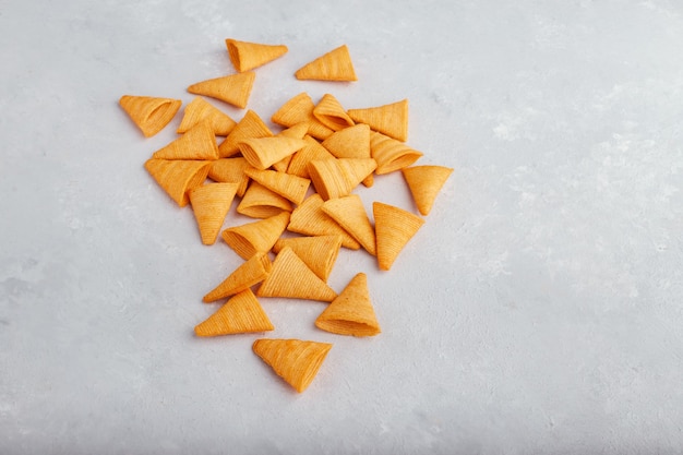 Kartoffelchips verteilen sich auf der weißen Oberfläche.