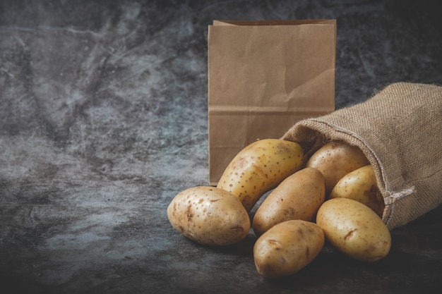 Kartoffeln gießen aus Säcken auf grauem Boden