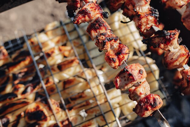 Kartoffeln und gegrilltes Fleisch. Feuer und Hitze. Kochen in der Natur.